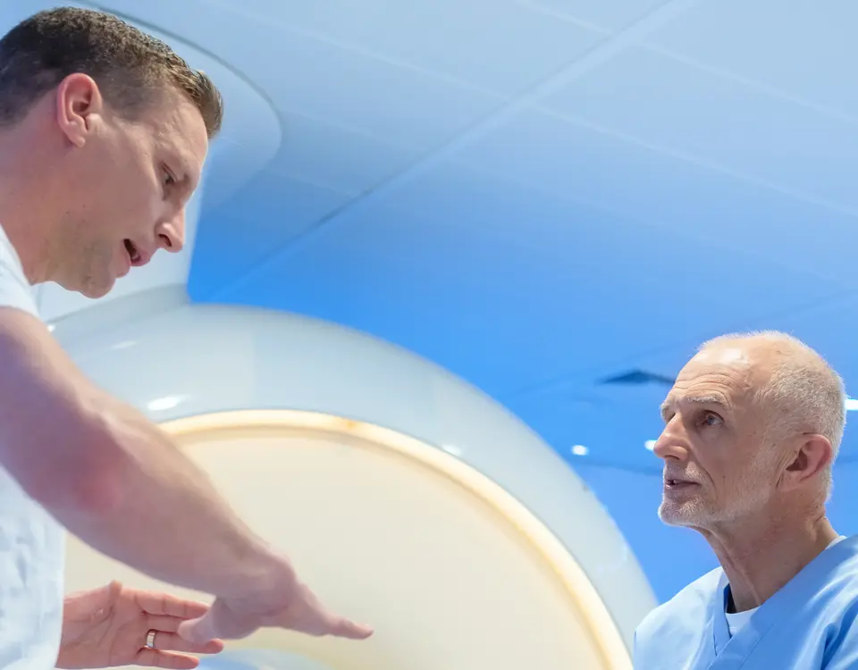 Arzt erläutert Patienten den Ablauf einer MRT-Untersuchung