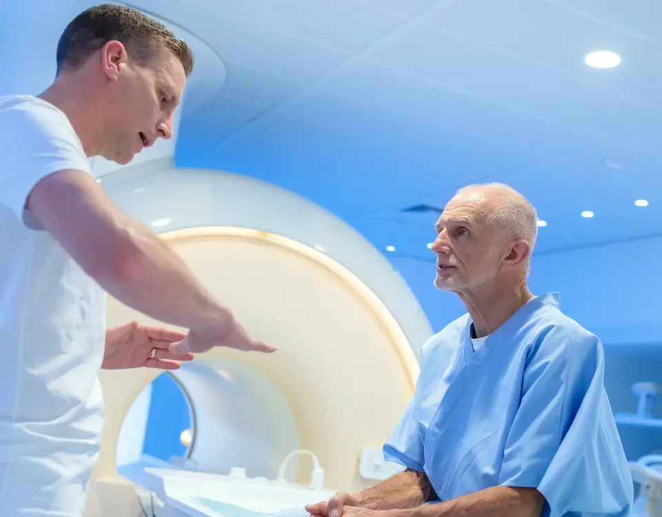 Arzt erläutert Patienten den Ablauf einer MRT-Untersuchung